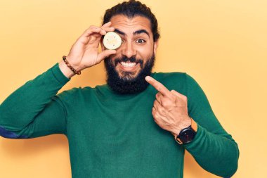 Genç Arap adam, salatalık sümüğünü tutarken gülümsüyor. 