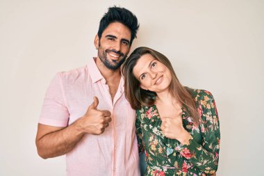 Güzel bir çift genç sevgili birlikte başarı işareti yapıyorlar. Elleriyle olumlu jest yapıyorlar. Gülümsüyorlar ve mutlular. Neşeli ifade ve kazanan jest. 