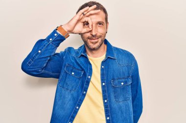 Genç, yakışıklı, günlük kıyafetler giyen, gülümseyen, mutlu, el pençe divan duran, el pençe divan duran. 