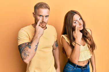 Genç bir çift kız arkadaş ve erkek arkadaş birbirlerine sarılıp göz göze bakıyorlar. Senin jestini izliyorlar. 