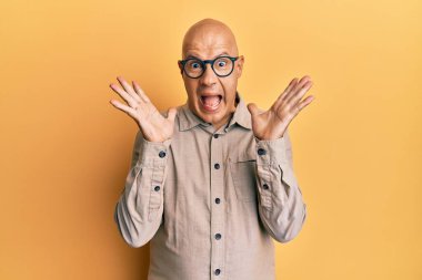 Orta yaşlı kel bir adam gündelik giysiler ve gözlük takıp çılgınlığı kutluyor ve başarıya hayret ediyor. Kolları havada ve gözleri açık, heyecanla bağırıyor. Kazanan konsept 