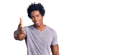 Yakışıklı Afro saçlı, sıradan kıyafetler giyen, samimi bir şekilde el sıkışarak selamlaşan Afro-Amerikan erkeği. başarılı iş. 