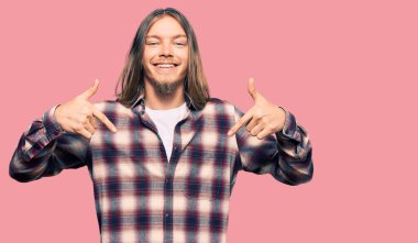 Uzun saçlı, yakışıklı, hippi tişörtlü, kendine güvenen, yüzünde gülümseme olan, kendini gururlu ve mutlu gösteren beyaz bir adam.. 