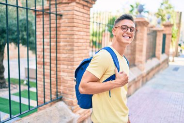 Genç İspanyol öğrenci gülümsüyor. Mutlu bir şekilde yürüyordu.
