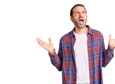 Genç, yakışıklı, sıradan kıyafetler giyen çılgın ve deli gibi bağıran agresif bir ifade ve kollarla bağıran bir adam. hüsran kavramı. 