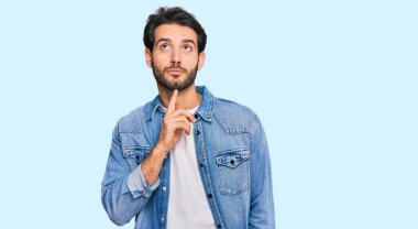 Gündelik kıyafetler giyen genç İspanyol adam şüphe üzerine yoğunlaşmıştı. Parmakları çenesinde ve yukarı bakıyordu. 