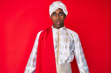 Gelenek giyinmiş yakışıklı Hintli adam Sherwani sari giysileri giyiyor. Şaşırtıcı bir ifade, korku ve heyecan dolu bir yüz ifadesi var.. 