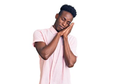 Genç Afro-Amerikan adam günlük kıyafetler giyip uyuyordu. Yorgundu. Hayal kuruyordu ve elleriyle poz veriyordu.. 