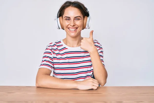 Masada Oturmuş Kulaklık Takan Genç Spanyol Kadın Mutlu Olumlu Gülümsüyor — Stok fotoğraf