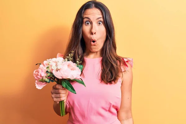 Giovane Bella Donna Bruna Possesso Bouquet Fiori Rosa Sfondo Giallo — Foto Stock