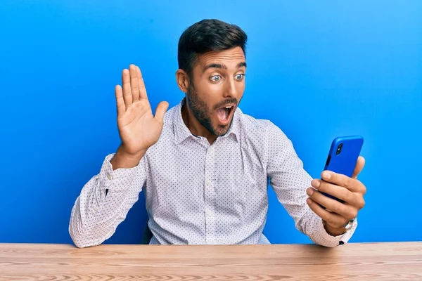 Handsome Hispanic Man Doing Video Call Waving Smartphone Afraid Shocked — Stock Photo, Image