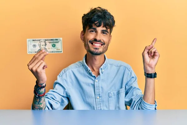 Jovem Hispânico Segurando Nota Dólares Sorrindo Feliz Apontando Com Mão — Fotografia de Stock