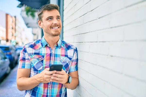 Joven Hombre Caucásico Sonriendo Feliz Usando Teléfono Inteligente Ciudad —  Fotos de Stock