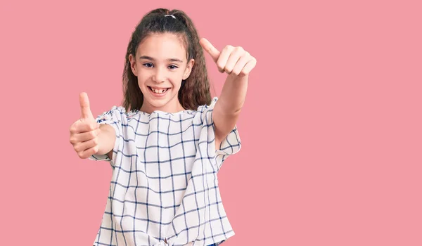 手で積極的なジェスチャーを行うことを承認カジュアル服を着てかわいいヒスパニック系の子供の女の子 親指アップ笑顔と成功のために幸せ 勝者のジェスチャー — ストック写真