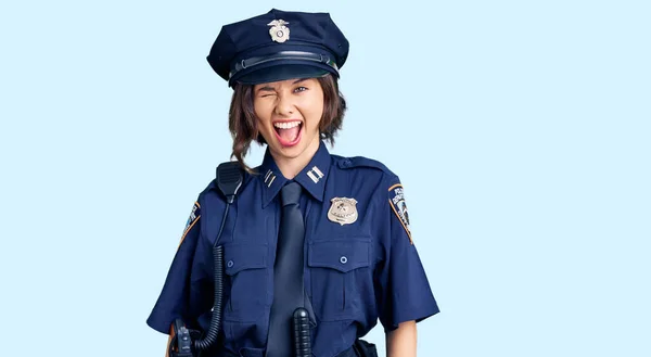 若いです美しいです女の子身に着けています警察制服ウィンク見ますザ カメラとともにセクシー表現 陽気で幸せな顔 — ストック写真
