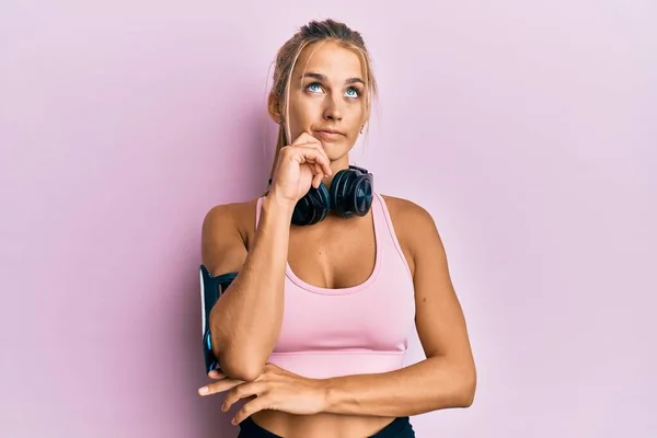 Νεαρή Ξανθιά Γυναίκα Φορώντας Ρούχα Γυμναστικής Και Χρησιμοποιώντας Ακουστικά Σοβαρό — Φωτογραφία Αρχείου