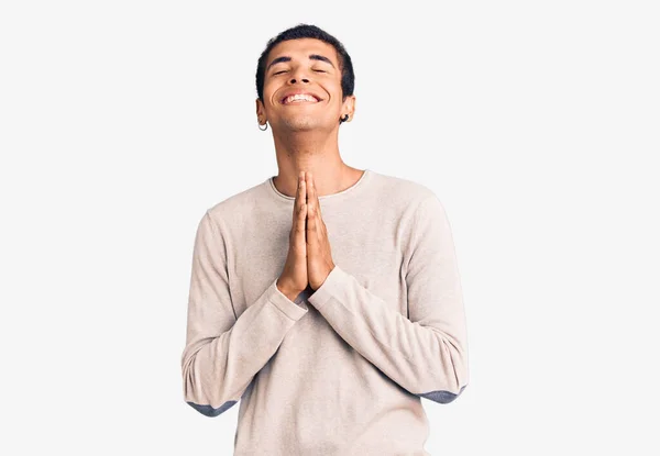 若いアフリカ系アメリカ人の男性は カジュアルな服を着て手で物乞いと祈りを一緒に顔に希望の表現は非常に感情的かつ心配しています お願い — ストック写真