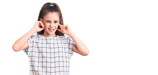 可爱的惊慌失措的小女孩穿着休闲服 用手指捂住耳朵 带着恼怒的表情 听着嘈杂的音乐 聋人概念 — 图库照片