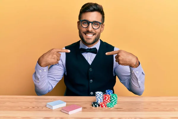 Yakışıklı Ispanyol Krupiyesi Poker Fişleri Kartlarla Masada Oturuyor Kendine Güler — Stok fotoğraf