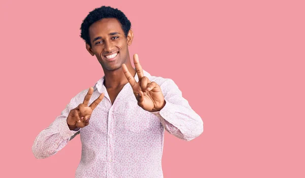 Africký Pohledný Muž Neformální Růžové Košili Usmívá Dívá Kameru Ukazující — Stock fotografie