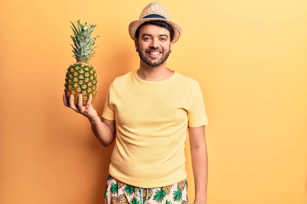 Mladý Hispánský Muž Plavkách Letním Klobouku Drží Ananas Vypadá Pozitivně — Stock fotografie