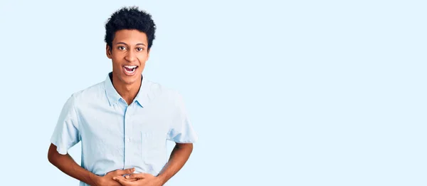 若いアフリカ系アメリカ人男性を身に着けているカジュアル服笑顔と笑いハードアウト大声でなぜなら面白いクレイジー冗談で手で体 — ストック写真