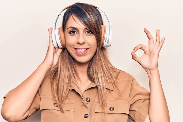 Joven Hermosa Mujer Escuchando Música Usando Auriculares Haciendo Signo Con — Foto de Stock