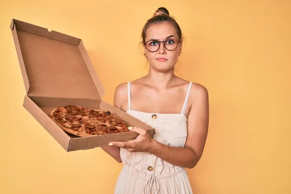 Piękna Biała Kobieta Trzymająca Smaczną Pizzę Pepperoni Sceptyczna Nerwowa Marszcząca — Zdjęcie stockowe