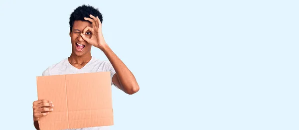 Joven Afroamericano Hombre Sosteniendo Cartulina Cartulina Sonriendo Feliz Haciendo Signo —  Fotos de Stock