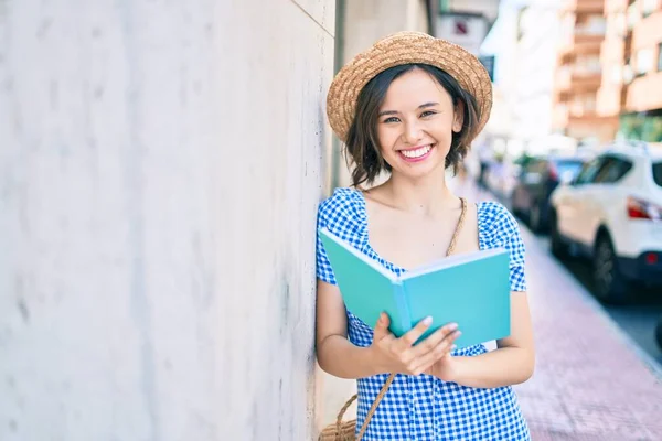 Молода Красива Дівчина Посміхається Щасливим Читанням Книги Спираючись Стіну Вулиці — стокове фото