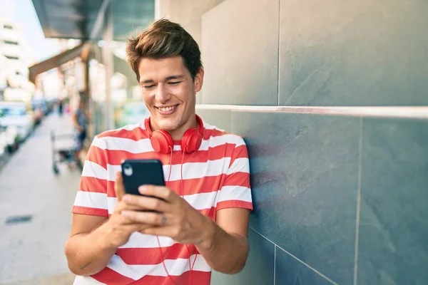 Mladý Běloch Šťastně Usmívá Pomocí Smartphonu Sluchátek Městě — Stock fotografie