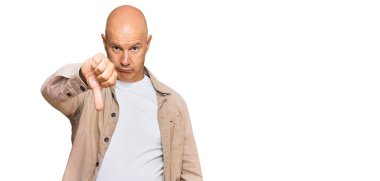 Orta yaşlı, kel, sıradan kıyafetler giyen mutsuz, kızgın, reddedilmiş ve olumsuz hareketler yapan bir adam. kötü ifade. 