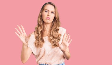 Sarışın, güzel, beyaz bir kadın. Sıradan kıyafetler giyiyor. Avuçlarını hareket ettiriyor, reddediyor ve iğrenç bir ifadeyle reddediyor. Dur ve yasakla. 