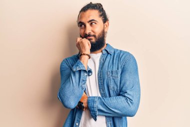 Gündelik giysiler giyen genç bir Arap şüphe üzerine yoğunlaşmıştı. Parmakları çenesinde ve yukarı bakıyordu. 