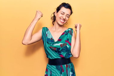 Genç ve güzel İspanyol kadın gündelik elbiseler giyiyor çok mutlu ve heyecanlı kazanan jestler yapıyor kolları havada, gülümsüyor ve başarı için bağırıyor. kutlama konsepti. 