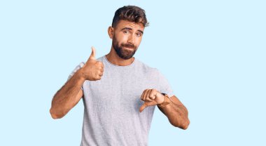 Latin asıllı genç bir adam günlük kıyafetler giyip baş parmak kaldırıyor, anlaşmazlık ve uzlaşma ifadesi. çılgın çatışma 