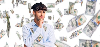 Gündelik tişört giyen genç İspanyol adam kameraya kollarını kavuşturup gülümseyerek ve çenesini kaldırarak bakıyor. Olumlu düşünmek.