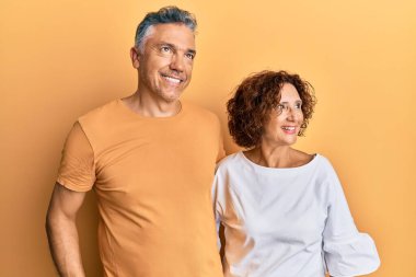 Güzel orta yaşlı çift, sıradan kıyafetler giyip gülümsüyor, yan tarafa bakıyor ve düşünüyor.. 