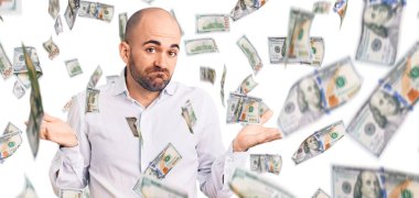 Zarif bir gömlek giyen, elleri ve kolları havada, kafası karışmış genç yakışıklı bir adam. şüphe kavramı.