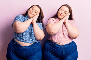 Genç ve cüsseli ikizler rahat kıyafetler giyip uyuyorlar. Yorgun düşler görüyorlar. Elleriyle poz veriyorlar.. 