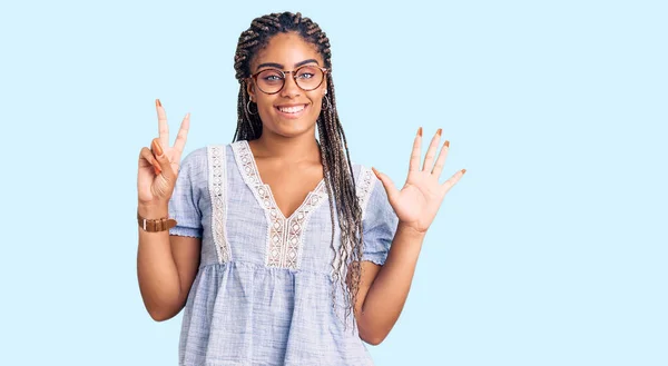 年轻的非洲裔美国女人 头戴辫子 穿着休闲的夏装 戴着眼镜 带着七号手指指尖 面带微笑 自信而快乐 — 图库照片
