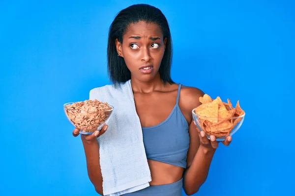 Jonge Afro Amerikaanse Vrouw Draagt Sportkleding Met Nacho Cornflakes Twijfelconcept — Stockfoto
