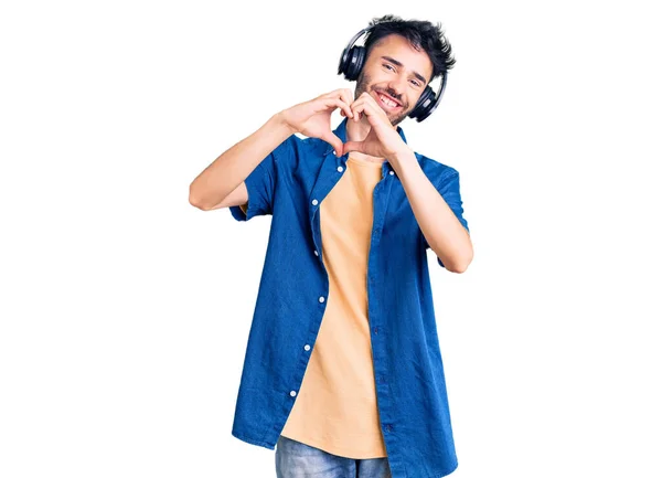 Young Hispanic Man Listening Music Using Headphones Smiling Love Showing — Stock Photo, Image