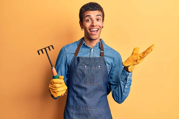 Jonge Afrikaanse Amerikaanse Man Draagt Tuinman Schort Handschoenen Met Hark — Stockfoto