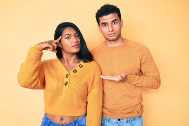 Güzel Latin genç çift, günlük kıyafetlerini giyerek avuçlarını açıp fotokopi alanını göstermekten rahatsız ve kafaları karışmış bir halde. Bunu bir düşün.. 