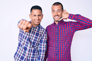 Gündelik giysiler giymiş, gülümseyen, telefonda konuşan ve seni işaret eden iki genç gay. Ara beni.. 