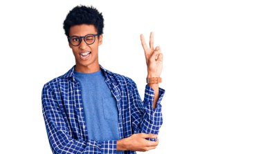 Sıradan kıyafetler ve gözlük takmış, kameraya gülümseyen ve zafer işareti yapan Afro-Amerikan genç bir adam. İki numara.. 