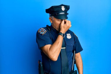 Handsome middle age mature man wearing police uniform tired rubbing nose and eyes feeling fatigue and headache. stress and frustration concept.  clipart