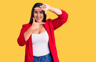 Güzel esmer, zarif kıyafetler giyen, gülümseyen, elleri ve parmakları gülen yüzlü bir kadın. yaratıcılık ve fotoğrafçılık kavramı. 