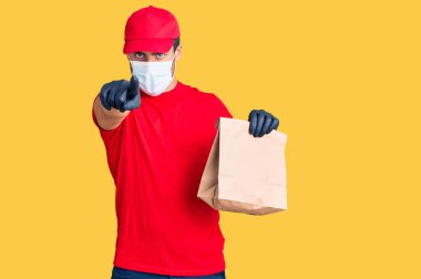 İspanyol asıllı genç bir adam elinde kağıt torbayla kamerayı ve seni işaret ederek yemek getiriyor. Kendine güveni tam bir jest. 